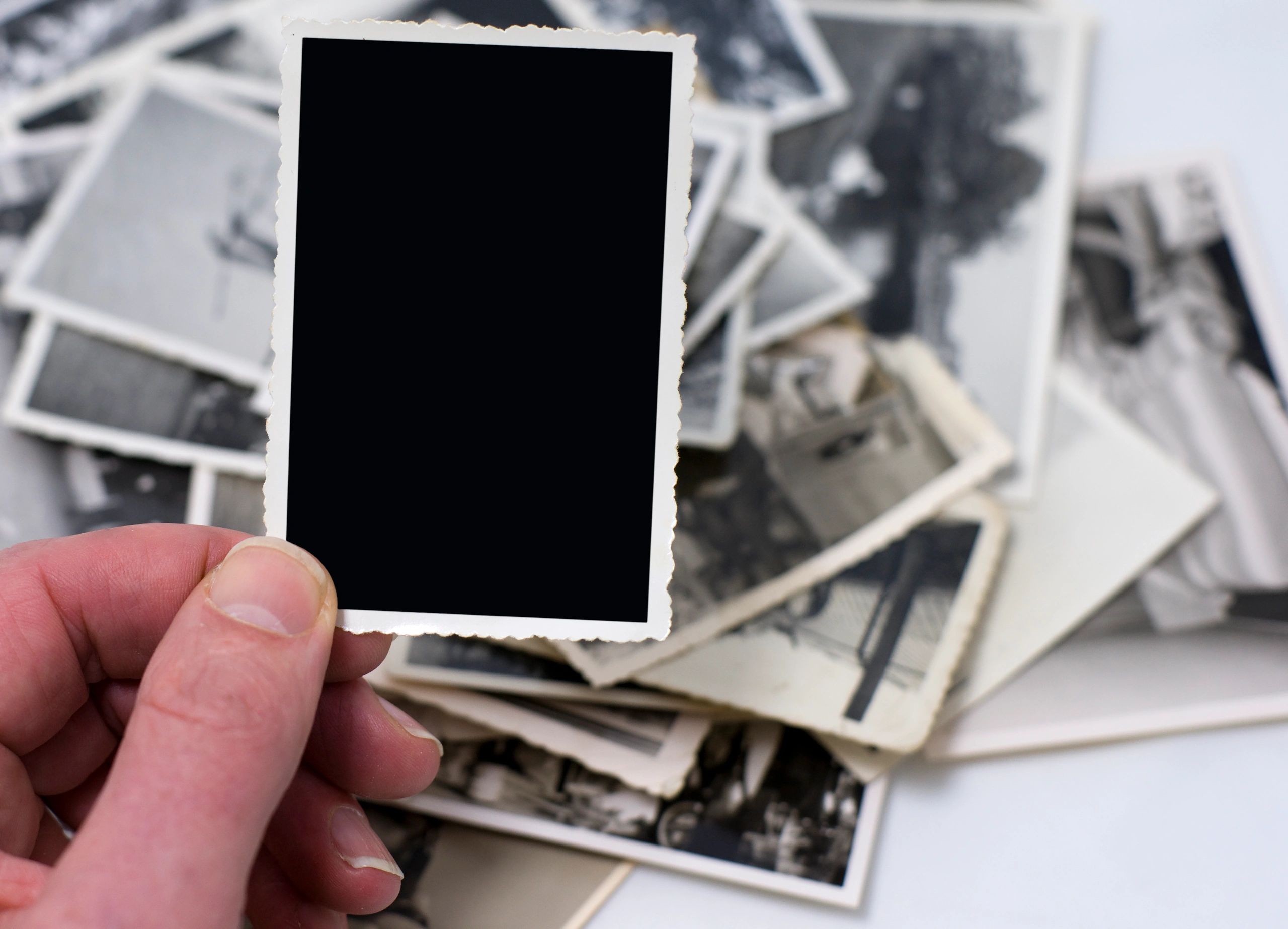 Hand holding a vintage photograph representing personal photo restoration work